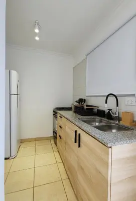 a kitchen with a sink and a refrigerator at Pent House Nueva Córdoba in Cordoba