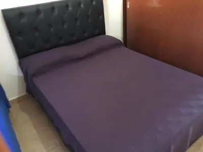 a small bed in a room with purple sheets at Depto temporario Carlos paz in Villa Carlos Paz