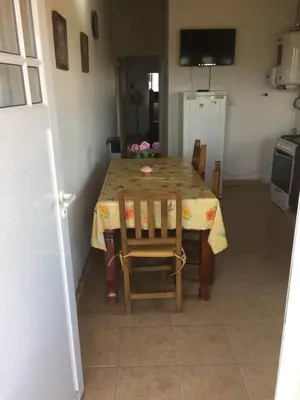 a dining room table with chairs and a table and a television at Depto temporario Carlos paz in Villa Carlos Paz