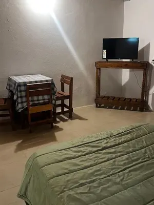 a bedroom with a bed and a table and chairs at Complejo Monarcas in Villa Carlos Paz
