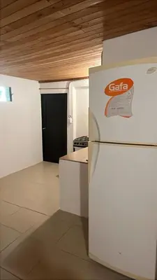 a kitchen with a white refrigerator and a black door at Complejo Monarcas in Villa Carlos Paz