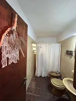a bathroom with two toilets and a sink and a shower at Casa Jazmín in Villa Carlos Paz