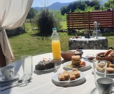 a table with plates of food and a bottle of orange juice at Cabaña Paz in Santa Rosa de Calamuchita