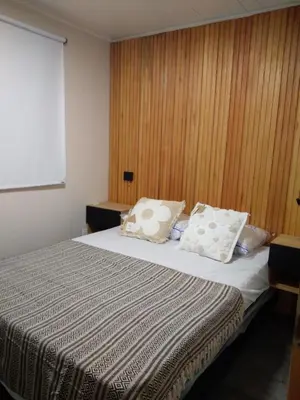 a bedroom with a bed with two pillows on it at Cabaña Villa Alpina,tanti córdoba in Tanti