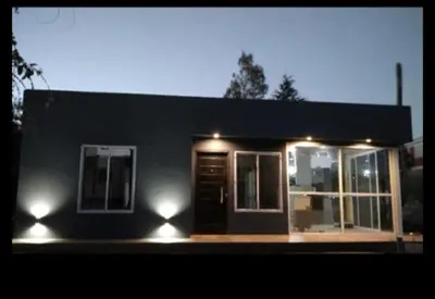a small house with lights on the front of it at Cabaña Villa Alpina in Tanti
