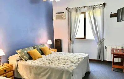 a bedroom with a large bed with yellow pillows at Hosteria de los Césares in Merlo