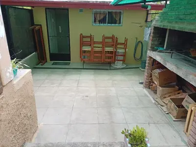 a patio with chairs in the back of a house at La Casita del tano con Pileta in Villa Carlos Paz