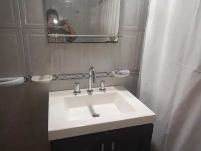 a person taking a picture of a sink in a bathroom at Divina providencia in Merlo