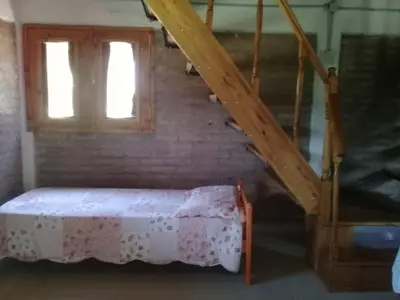 a room with a bed and a staircase with a window at La Fortaleza in Bialet Massé