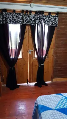 two black curtains in a room with a window at La Fortaleza in Bialet Massé