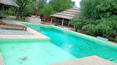 a large blue swimming pool with a bench next to it at cabañas Gerom in Pantanillo