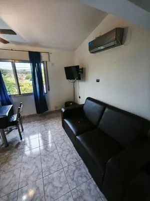 a living room with a black couch and a tv at Dpto Villa Carlos Paz max 5 personas