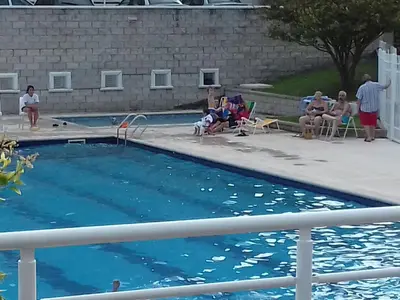 a group of people sitting around a swimming pool at Temporario en Villa Sol in Cordoba