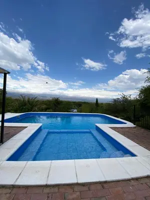 a large swimming pool with blue water at La Cuesta in Villa Cura Brochero