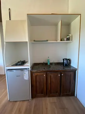 a small kitchen with a stove and a refrigerator at La cuesta in Villa Cura Brochero