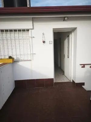 a hallway of a white building with a door and a doorway at Dpto Villa Carlos Paz max 5 personas in Villa Carlos Paz