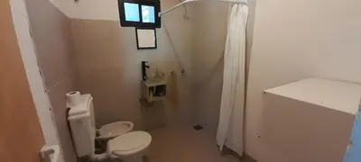 a white bathroom with a toilet and a window at Apartamento Jhaky in Villa Carlos Paz