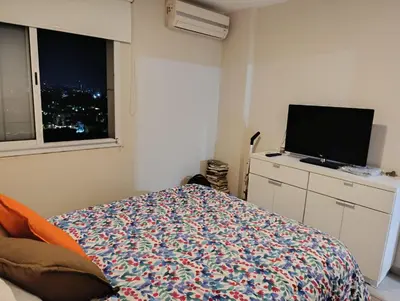 a bedroom with a bed and a flat screen tv at Dpto 1 dormitorio luminoso zona Nuevocentro in Cordoba