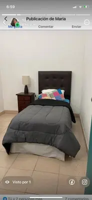 a bedroom with a bed with a black comforter at Habitación Individual con todas las comodidades in Cordoba