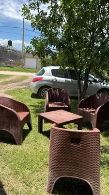 a picnic table and chairs in the grass near a car at Departamento Vilma Planta Baja Brochero in Villa Cura Brochero