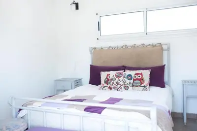 a bedroom with a white bed with pillows and a window at Casa Potrero de Garay in La Estancia