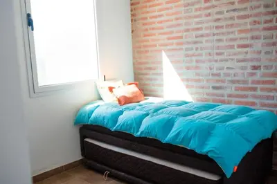 a bed in a room with a brick wall at Casa Potrero de Garay in La Estancia