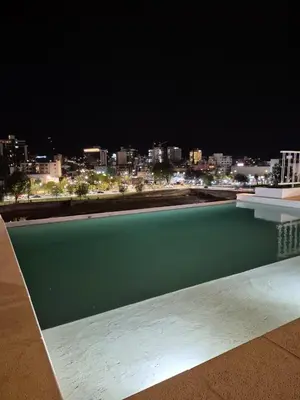a swimming pool with a view of a city at night at ALOJATE PREMIUM VILLA CARL0S PAZ - STEFANO 1 dor in Villa Carlos Paz