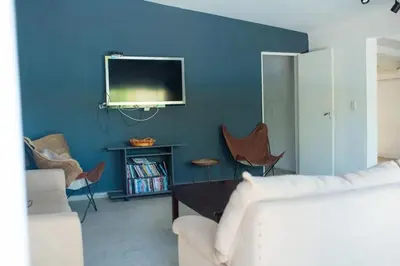 a living room with a tv on a blue wall at Casa Potrero de Garay pileta in La Estancia