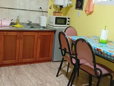 a kitchen with a table and two chairs and a sink at La Casita del Tano con Pileta in Villa Carlos Paz