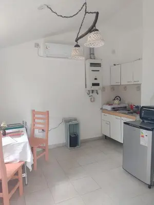 a kitchen with a table and a chair and a stove at La Calma in Los Reartes