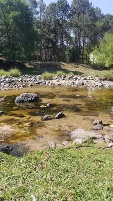 a river with rocks in the middle of a field at La Calma in Los Reartes