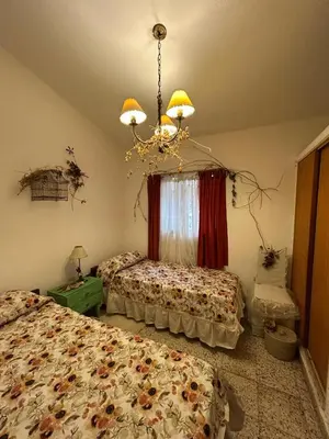 a bedroom with two beds and a chandelier at Casa Jaz in Villa Carlos Paz