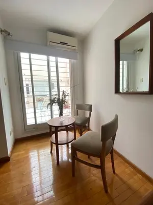 a living room with a table and chairs and a mirror at Departamento Nuñez in Cordoba