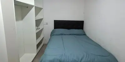 a small bedroom with a bed with a black headboard at Apartamento Jhaky 2 in Villa Carlos Paz