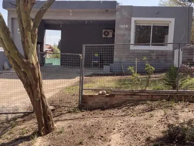 a fence in front of a house with a dog at Portal del rio mina clavero in Mina Clavero