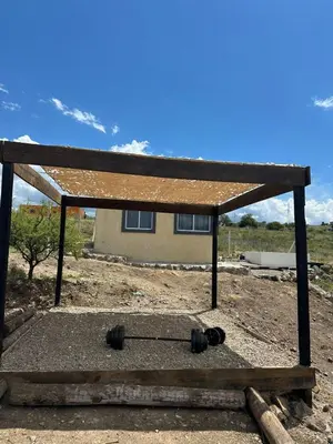 a building with a roof on top of a field at ecolodge in San Pedro