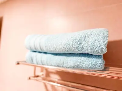 a stack of towels on a shelf in a bathroom at Departamento de lujo frente al quality espacio in Cordoba