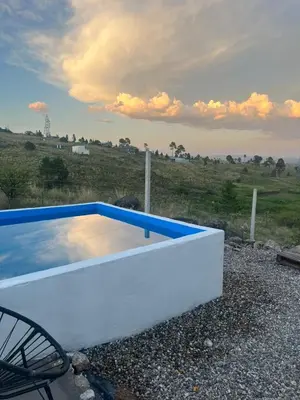 a white and blue swimming pool in a field at Ecolodge in Potrero de Garay