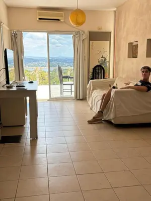a man sitting on a bed in a hotel room at Departamento con increible vista in Villa Carlos Paz