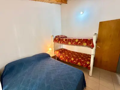 a small bedroom with a bed and a bunk bed at Casa Los Prados Mina Clavero in Mina Clavero