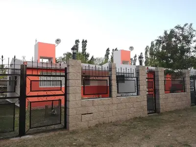 a brick fence with red windows and gates at mi casita en tanti, casa 25 in Tanti