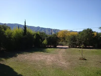 a large yard with trees and mountains in the background at Casa Del Mirador in Bialet Massé