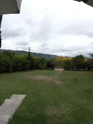a grassy field with trees and mountains in the background at Casa Del Mirador in Bialet Massé