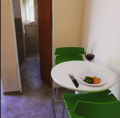 a white table with a plate of food and a glass of wine at Hostel 2 in Pilar