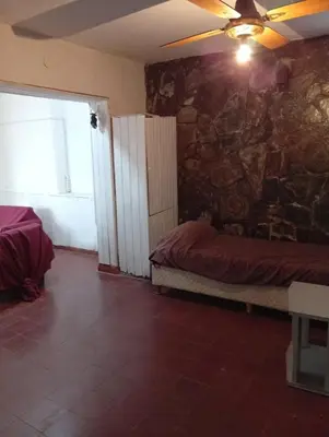 a bedroom with a stone wall with a bed and a ceiling at casa en Tanti in Tanti