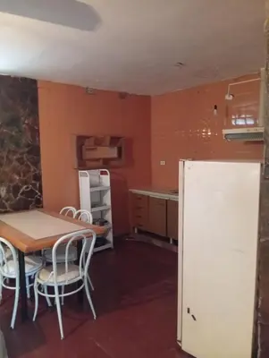 a kitchen with a table and a white refrigerator at casa en Tanti in Tanti