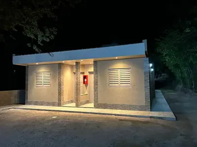 a small building with a red door in the night at El Atardecer in Trapiche