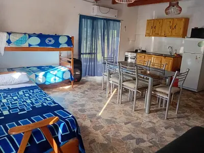 a room with a table and chairs and a kitchen at La grina in Bialet Massé