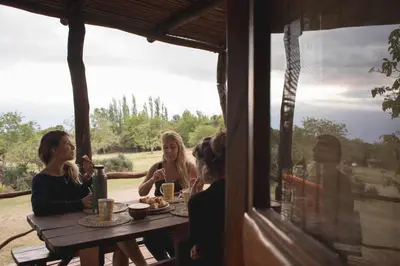 a group of women sitting around a wooden table at Cabañas Bendita Tierra 1 in Los Molles