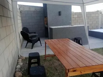 a patio with a wooden table and chairs and a tub at Casa Francesca in Villa Carlos Paz